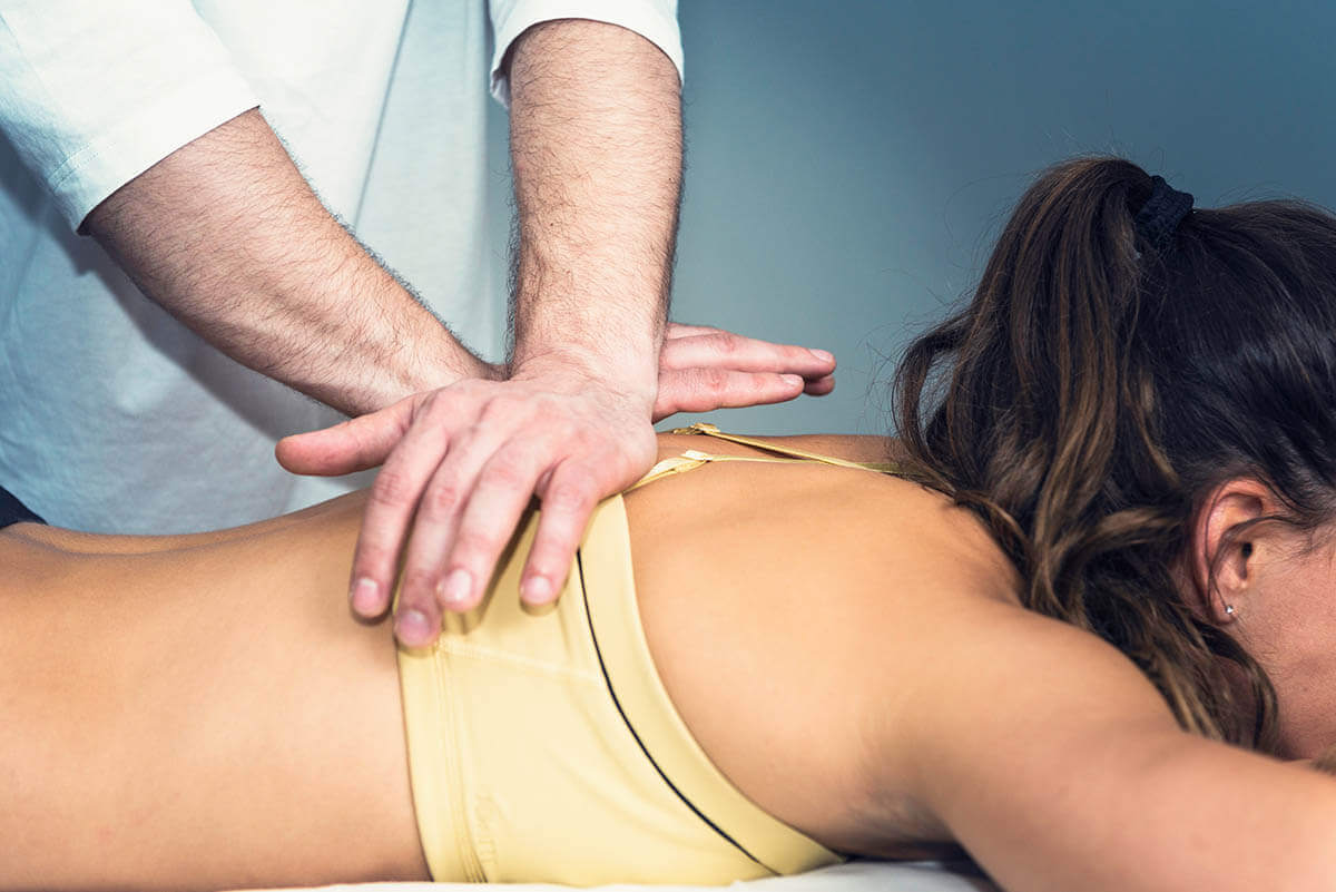 a lady taking chiropractic care for backpain at walker chiropractor center